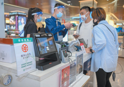 全球生活新门：2022年5月3日，顾客正在海南省海口市的免税商场内使用数字人民币
